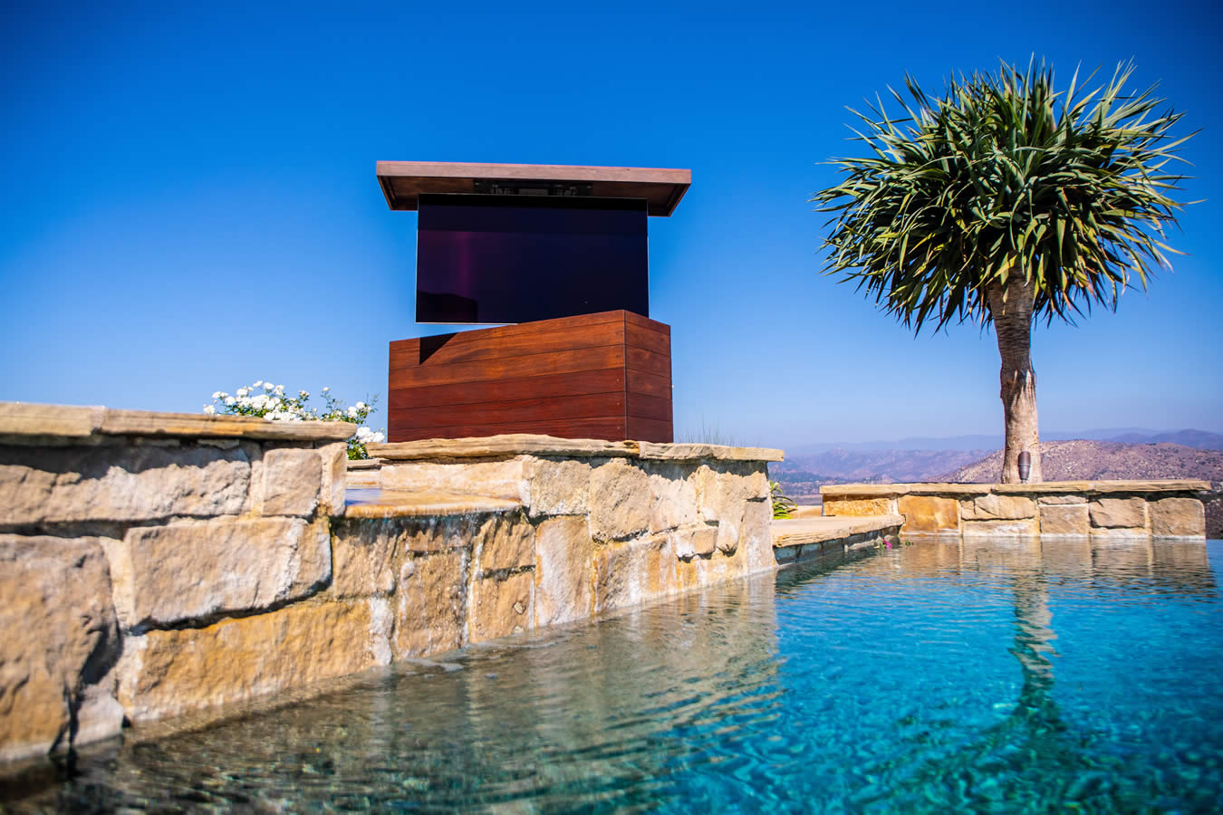 T-Top Cumaru outdoor TV lift furniture by the pool spa and sitting area