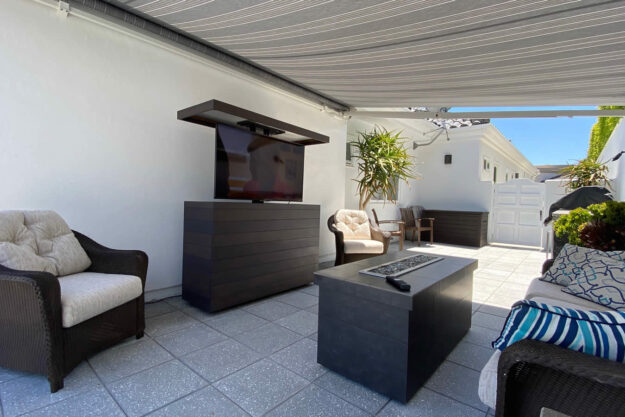 Outdoor hidden TV lift cabinet gets moved to other backyard locations by Cabinet Tronix California